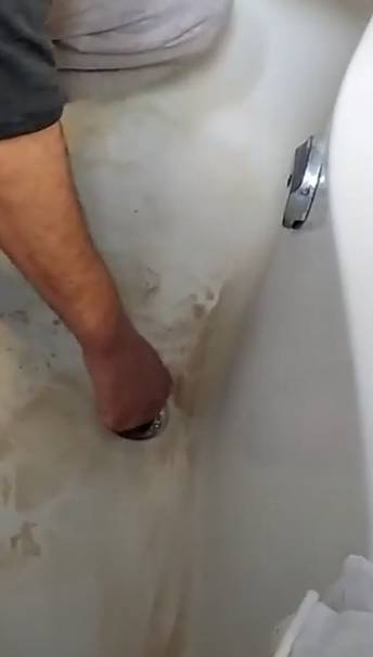 guy removing tub drain