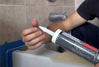 guy with tube of adhesive for tub surround